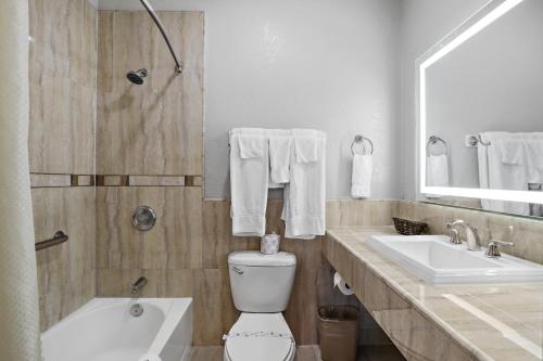 a bathroom with a toilet and a sink and a tub at Motel Mediteran in Escondido