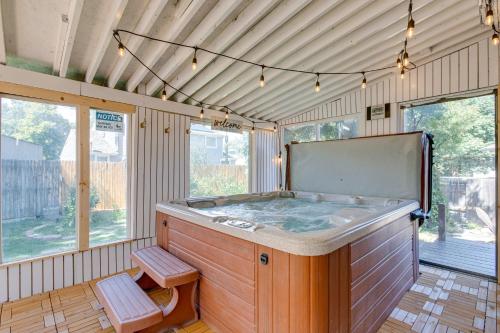 a hot tub in the middle of a room with windows at Spacious Aurora Retreat with Game Room and Hot Tub! in Aurora