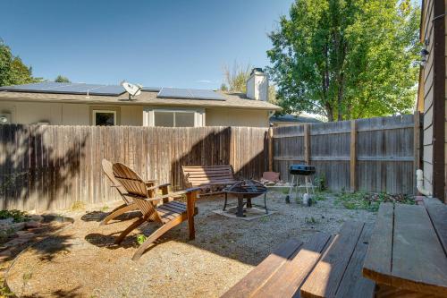 a backyard with a fence and a bench and a grill at Spacious Aurora Retreat with Game Room and Hot Tub! in Aurora