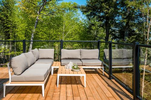 a deck with two couches and a coffee table at Chalet Alpine by Tremblant Platinum in La Conception