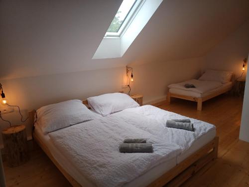 een slaapkamer met een bed met witte lakens en een raam bij srub U Holubů in Malšice