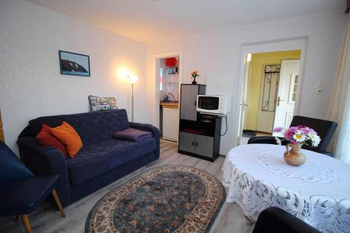 a living room with a blue couch and a table at Ferienhaus Mattke in Sassnitz