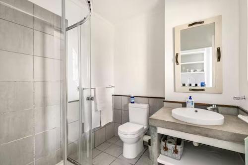 a bathroom with a toilet and a sink and a shower at Lea's Furnished Apartments - Dainfern in Sandton