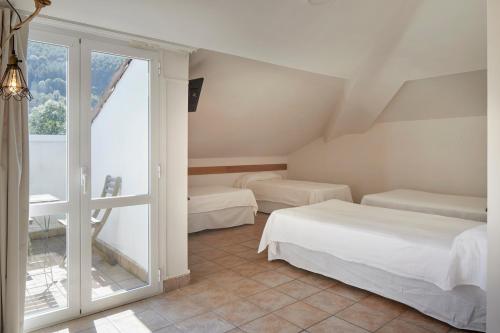 a bedroom with two beds and a large window at Leizarooms in Leitza