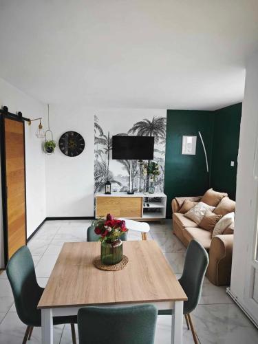 a living room with a table and a couch at Calais Plage-Gare Appartement élégant tout équipé in Calais
