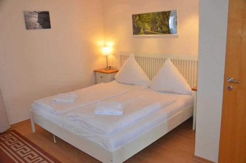 a bedroom with a bed with white sheets and pillows at Fürstenhof - Ferienwohnung 403 in Sassnitz