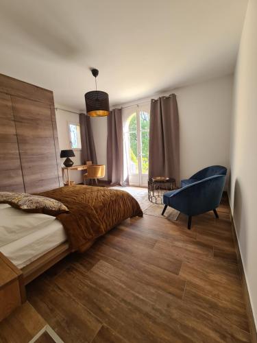 une chambre avec un grand lit et une chaise bleue dans l'établissement Villa ELEA Suites de luxe, à Nice