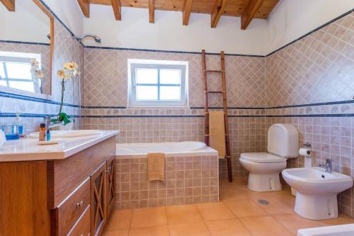 a bathroom with a tub and a toilet and a sink at Pita's House - Villa Sagres 2 in Sagres