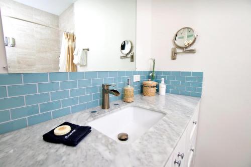 baño con lavabo blanco y azulejos azules en The No Problem at Cottages, en Sand Bluff