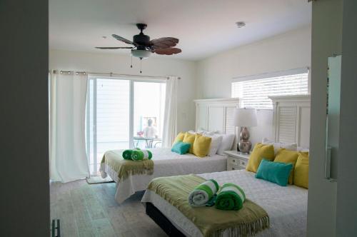 a bedroom with two beds and a ceiling fan at The Sand Dollar at Cottages in Sand Bluff
