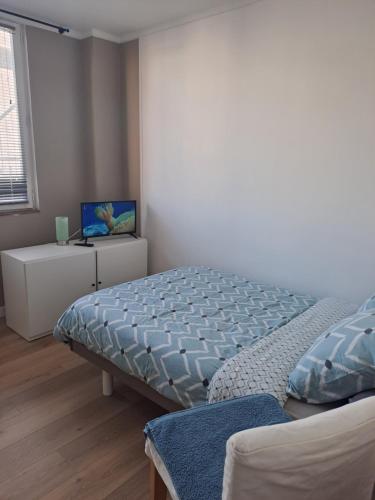 une chambre avec un lit et un bureau avec un ordinateur portable dans l'établissement Appartement tout confort Lumineux, à Paris