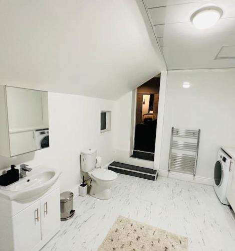 a white bathroom with a sink and a toilet at Bespoke 2 Bedroom Apt Derby City in Derby