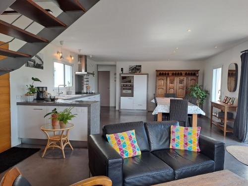 un salon avec un canapé et une cuisine dans l'établissement Maison traditionnelle et moderne avec vue mer, à Tréffiagat