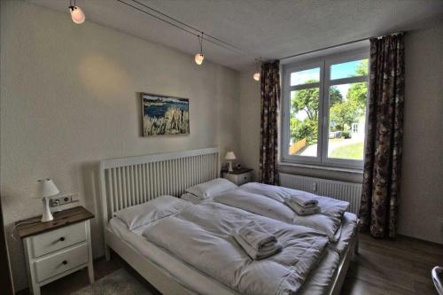 - une chambre avec un grand lit et une fenêtre dans l'établissement Villa Seeblick Apartment 307, à Sassnitz