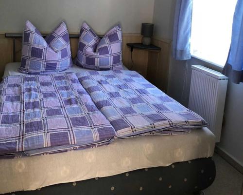 ein Bett mit lila Kissen in einem Schlafzimmer in der Unterkunft Ferienhaus Karger in Marlow