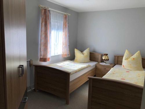 2 Einzelbetten in einem Zimmer mit Fenster in der Unterkunft Ferienhaus Karger in Marlow