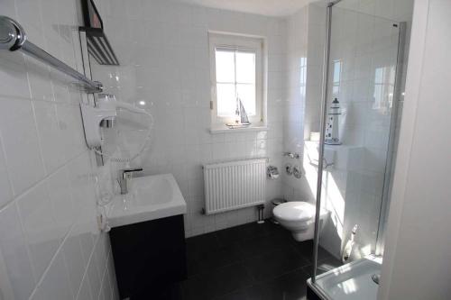 a white bathroom with a sink and a toilet at Ferienwohnung Kranichglück in Neddesitz
