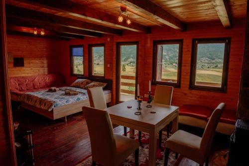 een slaapkamer met een bed en een tafel en stoelen bij Villa Forestside in Pluzine