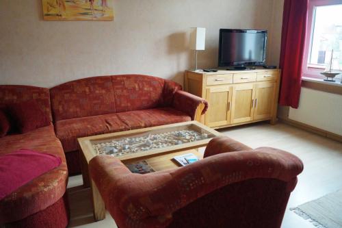 ein Wohnzimmer mit 2 Sofas und einem TV in der Unterkunft Ferienwohnung Frömming in Sassnitz