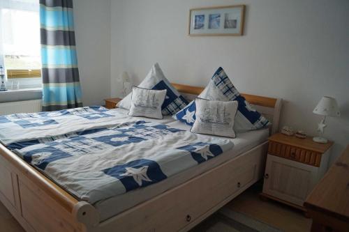 Bett mit blauer und weißer Bettwäsche und Kissen in der Unterkunft Ferienwohnung Frömming in Sassnitz