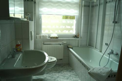 ein Badezimmer mit einer Badewanne, einem WC und einem Waschbecken in der Unterkunft Ferienwohnung Frömming in Sassnitz