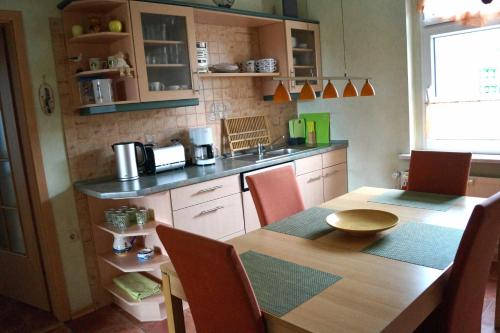 a kitchen with a wooden table with chairs and a dining room at Ferienwohnung Frömming in Sassnitz