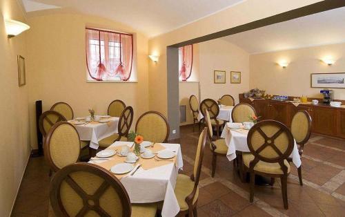un ristorante con tavoli e sedie in una stanza di Hotel Raffaello Prague a Praga