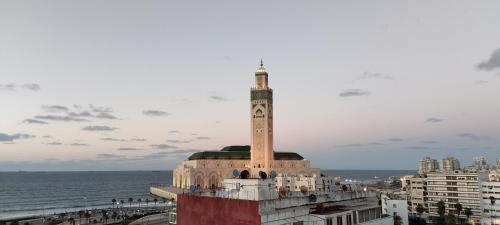 a clock tower on top of a building next to the ocean at Appartement Panoramique in Casablanca
