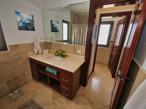 uma casa de banho com um lavatório e um espelho grande em Pearl Court 1111 at Pristine Bay em French Harbor