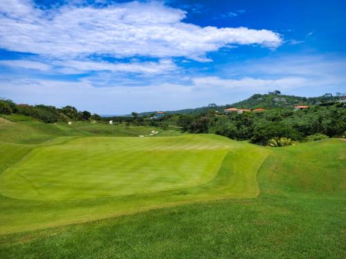 a view of a lush green golf course at Luxury Villa In Prestigious Pristine Bay, Home Of The Black Pearl Golf Course in French Harbour