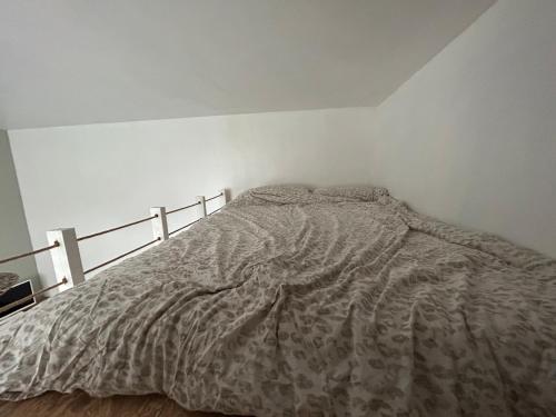 um quarto com uma cama com um edredão em Lovely studio Crimee em Paris