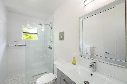 y baño con lavabo, aseo y espejo. en Snug Harbour View Condo #2 en George Town
