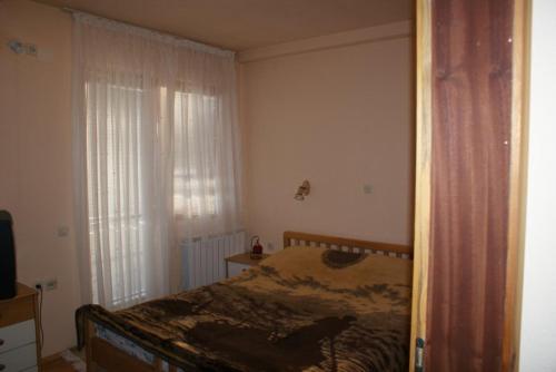 um quarto com uma cama e uma janela em Jovanoski Apartments em Struga