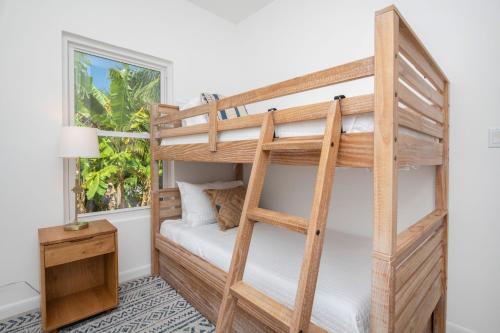Łóżko piętrowe w pokoju z biurkiem i oknem w obiekcie The Mastic Sunnyhill Cottage w mieście North Side