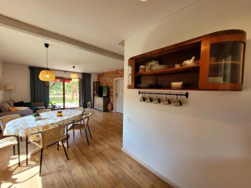a dining room and living room with a table and chairs at Borsk Sielanka in Borsk