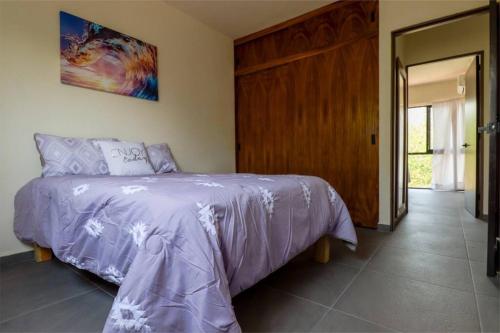 a bedroom with a bed with a purple comforter at Condo Temis Vallarta in Puerto Vallarta