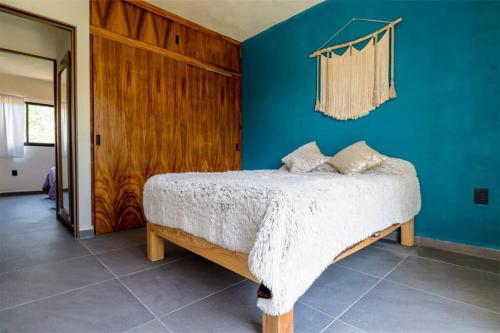 1 dormitorio con cama y pared azul en Condo Temis Vallarta, en Puerto Vallarta