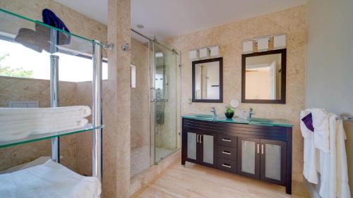 a bathroom with a shower and a sink and a mirror at Seven Mile View Condo #2 in West Bay