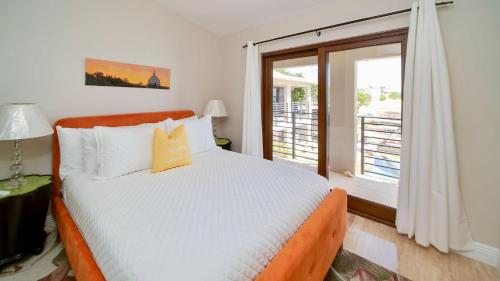 sypialnia z łóżkiem i dużym oknem w obiekcie Seven Mile View Condo #2 w mieście West Bay