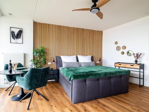 Un dormitorio con una cama de mechón verde y una mesa en Hotel Tower I 26th floor I Boxspring I Nespresso, en Augsburg