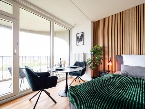 Schlafzimmer mit einem Bett, einem Tisch und Stühlen in der Unterkunft Hotel Tower I 26th floor I Boxspring I Nespresso in Augsburg