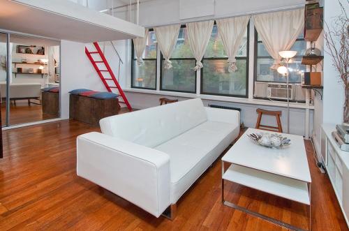 sala de estar con sofá blanco y mesa en Midtown East Next to Times Square, en Nueva York
