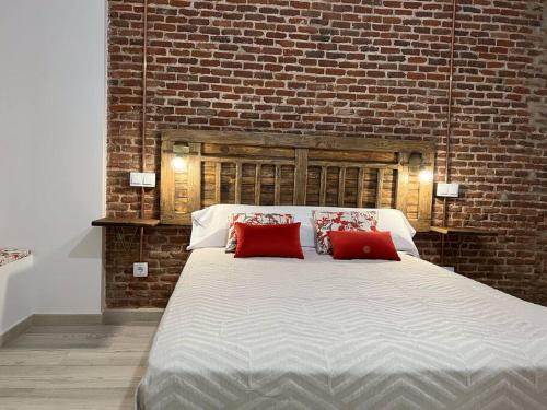a bedroom with a large bed with two red pillows at Redondilla in Madrid