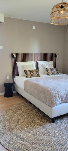 Un dormitorio con una cama grande con almohadas. en Vakantiewoning Meerssen Valkenburg Maastricht en Meerssen