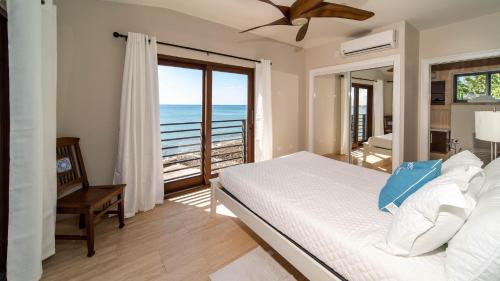 a bedroom with a bed and a view of the ocean at Seven Mile View Condo #1 in West Bay