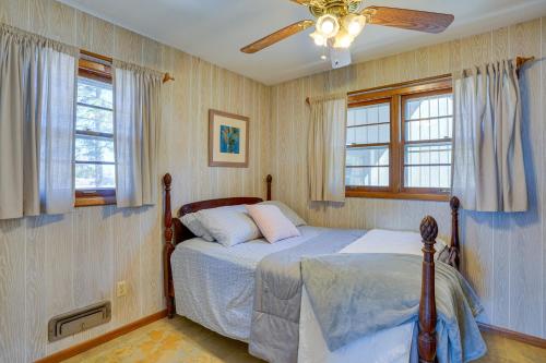 Schlafzimmer mit einem Bett, einem Deckenventilator und Fenstern in der Unterkunft Cedar Lake Retreat with Boathouse and Dock! in New Prague