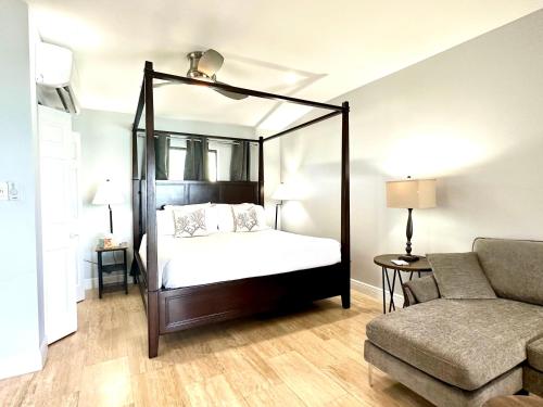 1 dormitorio con cama con dosel y sofá en Seven Mile View Condo #3B en West Bay