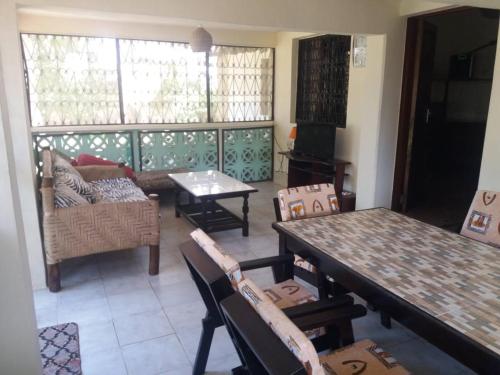 sala de estar con mesa y sofá en serene house to let in Diani en Kwale