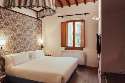 1 dormitorio con cama blanca y ventana en II Guelfo Bianco, en Florencia