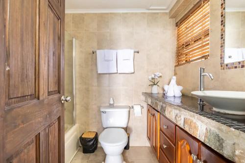 a bathroom with a toilet and a sink at Water Lovers Paradise! in Ocho Rios